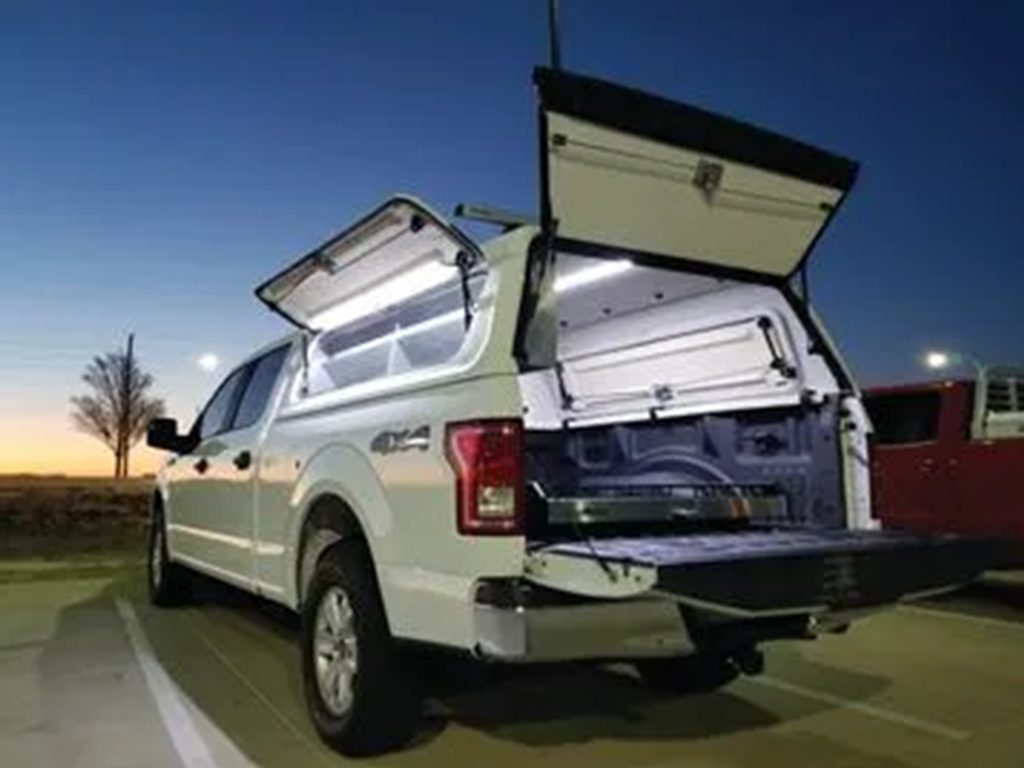 White truck with open commercial camper shell, interior lighting, and storage, showcasing Canyon State products.