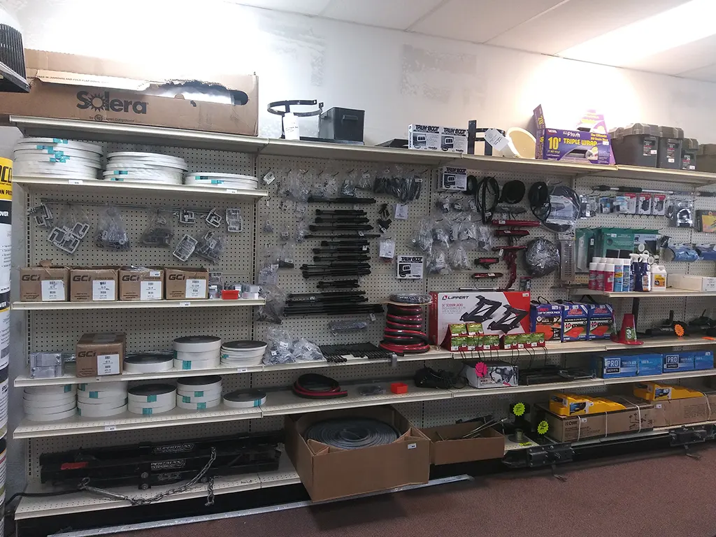 Shelves stocked with RV and trailer parts, including hoses, brackets, wiring, and hardware at Canyon State.