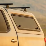 Truck bed cap from Canyon State with a rear window and roof rack mounted on a vehicle.