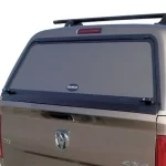 Rear view of a "Ranch" truck bed cap from Canyon State on a Dodge Ram with a window and roof rack.