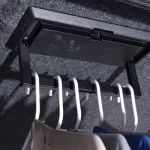 Clothes rack inside a truck bed cap from Canyon State, holding clothing in a compact space.