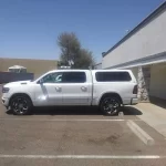 White Ram truck with a Ranch Echo camper shell parked outside Canyon State RV.