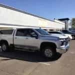 Silver truck with a Ranch Echo camper shell parked outside Canyon State RV.