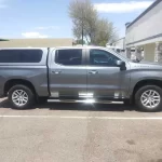 Gray truck with a Ranch Echo camper shell parked outside Canyon State RV.