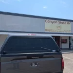 Back view of a Ford truck with a Ranch Echo camper shell outside Canyon State RV.