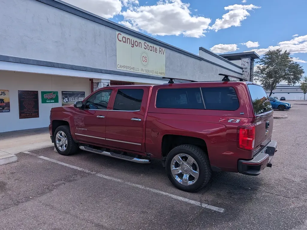 Red Chevrolet Silverado with a fiberglass camper shell, showcasing fiberglass camper shell products at Canyon State.