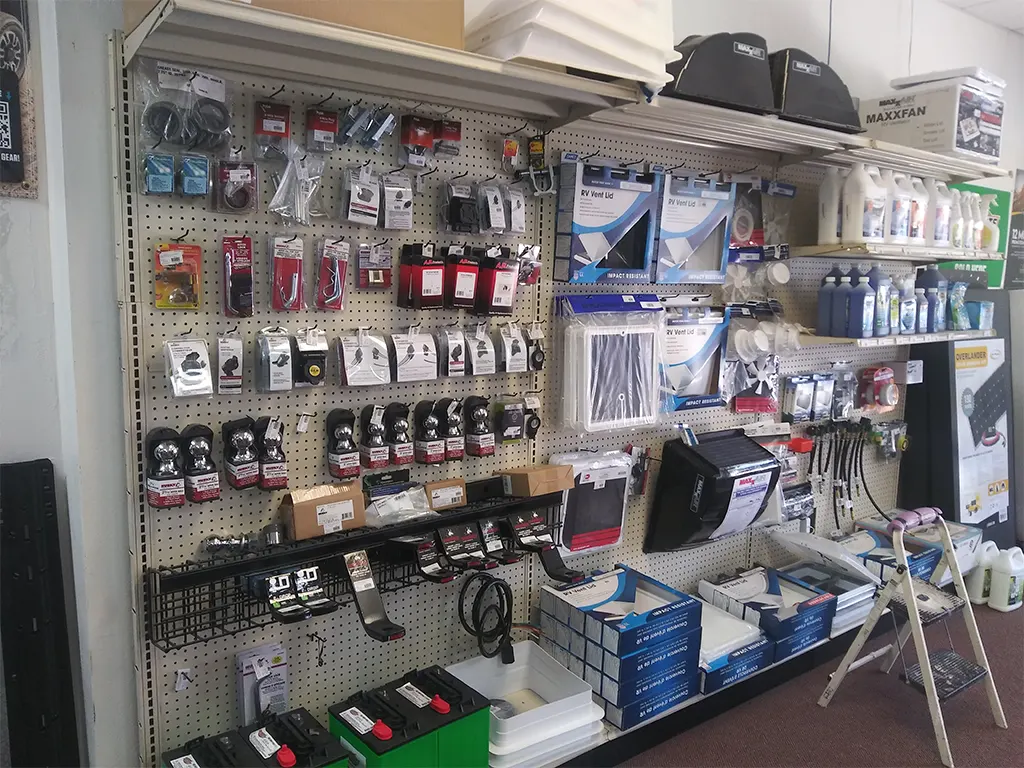 Wall display of truck and RV accessories, including hitches, vent lids, and cleaners, at Canyon State.